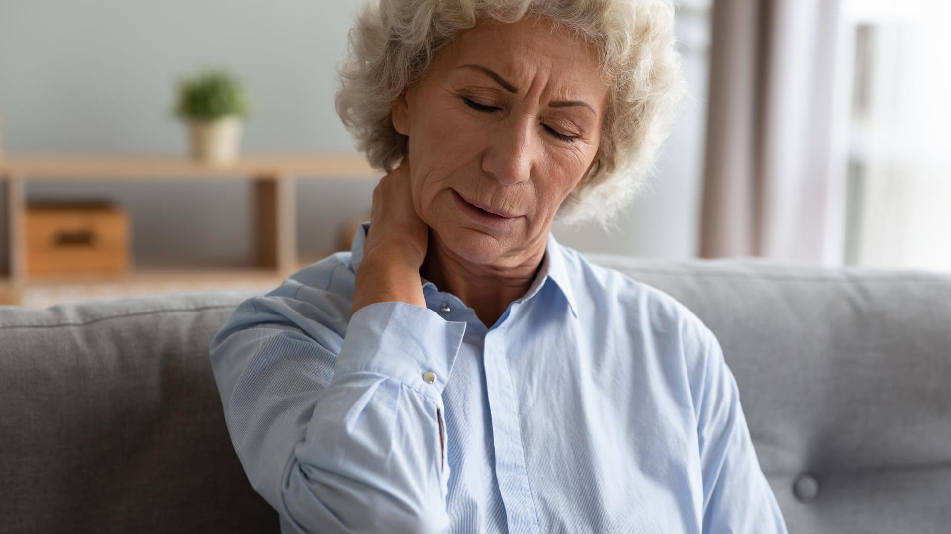 Frau mit Schmerzen im Nacken: Fibromyalgie kann auch die Rückenmuskulatur betreffen.