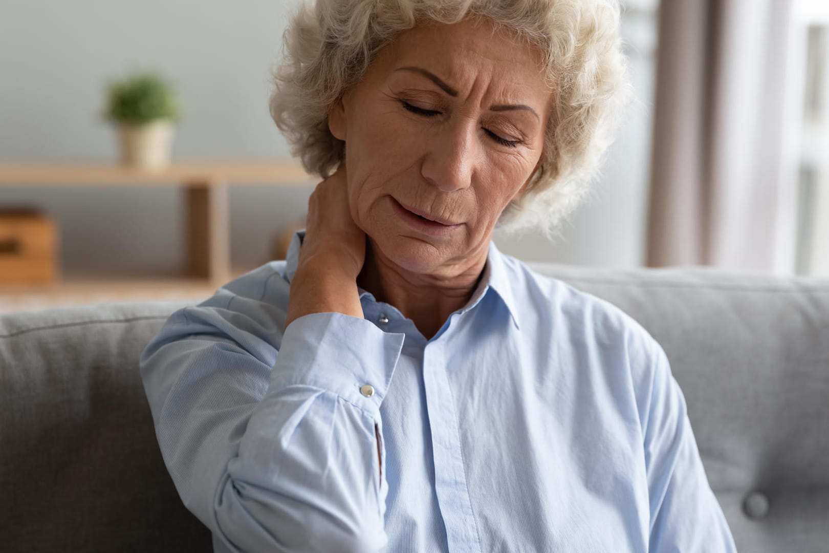 Frau mit Schmerzen im Nacken: Fibromyalgie kann auch die Rückenmuskulatur betreffen.