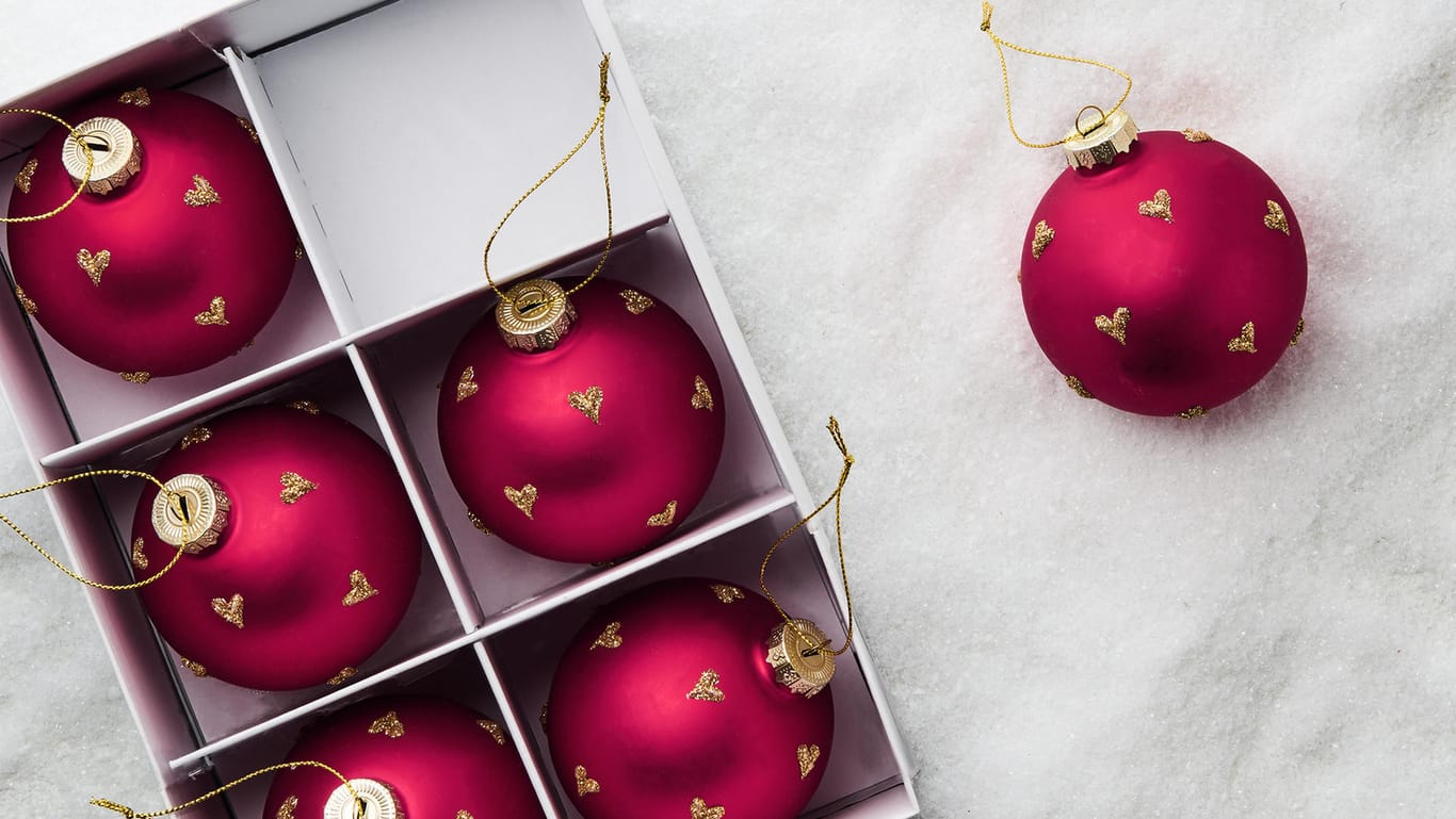 Weihnachtsbaumschmuck: Glaskugeln in Rot, hier mit goldenen Herzchen verziert, gehören zu den Klassikern.