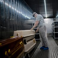 Ein Angestellter einer Leichenhalle in Johannesburg überprüft in einem Kühlcontainer Särge mit Corona-Opfern: In Südafrika wurde eine neue Variante des Coronavirus entdeckt.