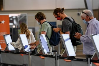 Personen warten am Flughafen (Symbolbild): In den Niederlanden sind bei 13 Reisenden Infektionen mit der Omikron-Variante festgestellt worden.