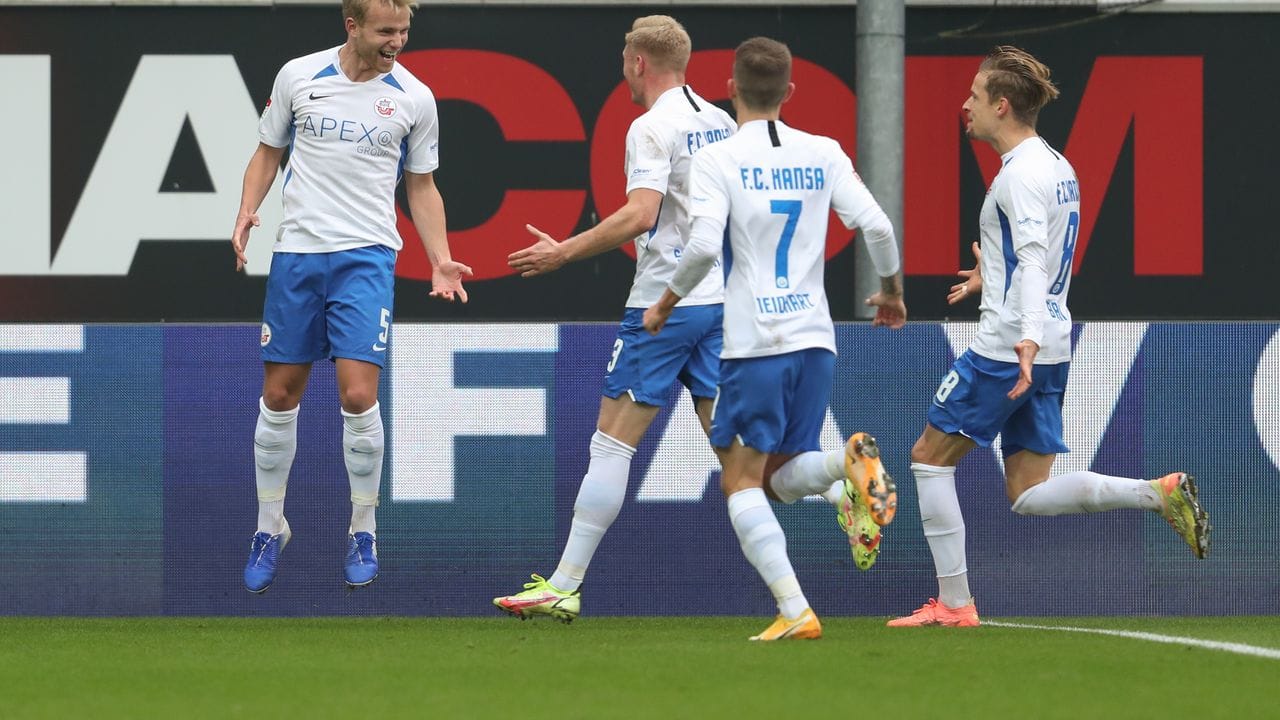 Rostocks Simon Rhein (l) feiert seinen Treffer zum 1:0 beim SC Paderborn mit Lukas Fröde (2.