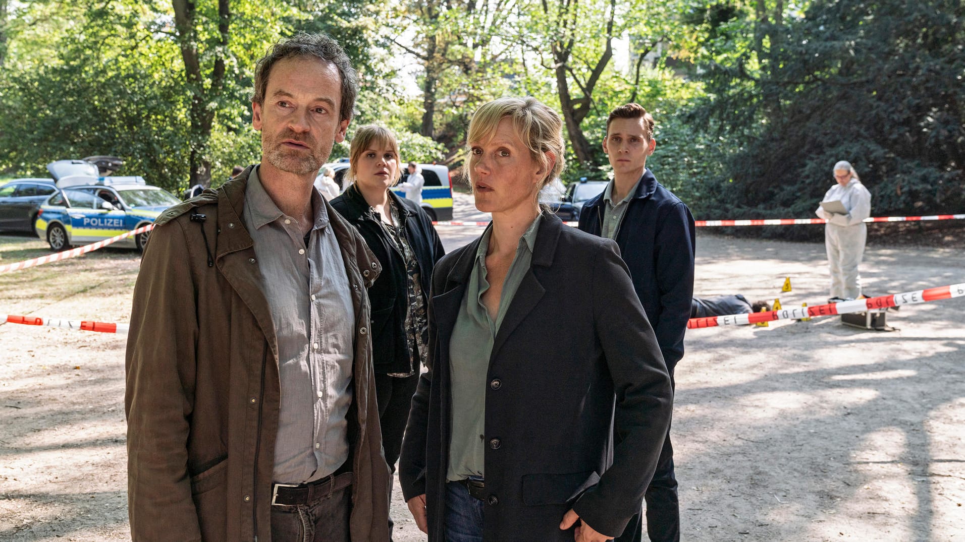 Tatort im Park: Ein Polizist wurde getötet – die Peter Faber (Jörg Hartmann), Rosa Herzog (Stefanie Reinsperger), Martina Bönisch (Anna Schudt) und Jan Pawlak (Rick Okon) schauen sich um, während Rechtsmedizinerin das Opfer untersucht.