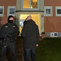 Einsatzkräfte der Polizei stehen vor dem Wohnhaus in Bad Windsheim: Darin fanden Beamte die leblose 33-Jährige und ihren Ex-Mann, der festgenommen wurde.