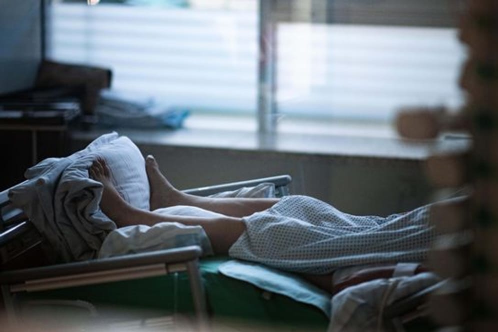Ein Patient liegt in einem Zimmer auf einer Corona-Intensivstation.