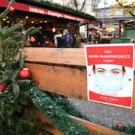 Hinweis auf die Maskenpflicht auf einem Münchner Weihnachtsmarkt: Kommt die "epidemische Lage von nationaler Tragweite" zurück?