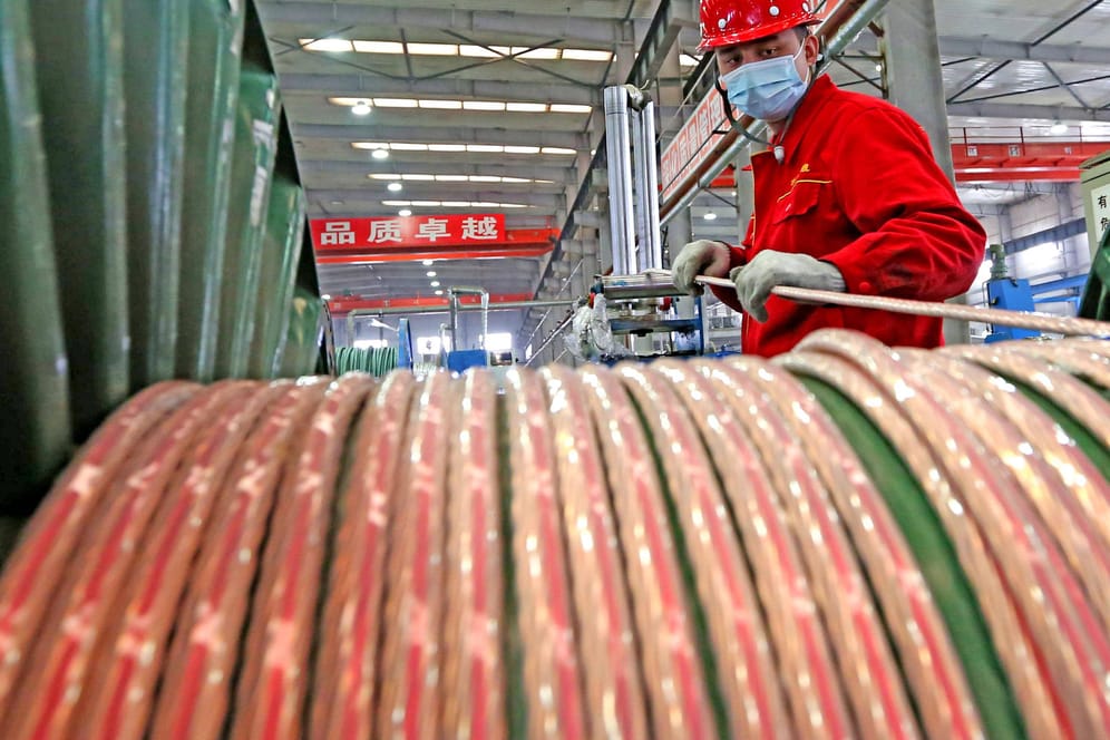 Ein Arbeiter in einer Fabrik in Xinjiang (Symbolbild): Lieferengpässe und Corona-Ausbrüche ließen die chinesische Wirtschaft monatelang stagnieren.
