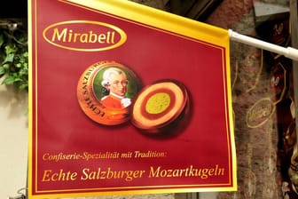 Fahne "Echte Salzburger Mozartkugeln" vor einem Schaufenster in der Altstadt von Salzburg: Der Hersteller der Süßwaren ist insolvent.