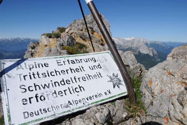 Ein Schild des Deutschen Alpenvereins weist auf mögliche Gefahren hin.