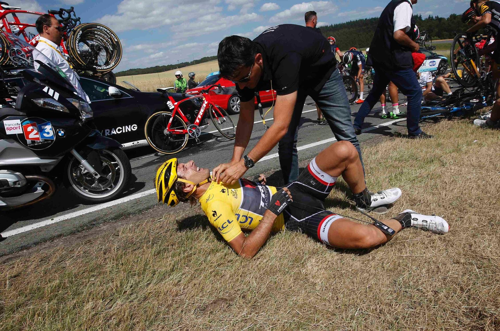 Race leader and yellow jersey holder Trek Factory rider Fabian Cancellara of Switzerland receives assistance as he lies on the ground after a fall during the third stage of the 102nd Tour de France cycling race from Anvers to Huy