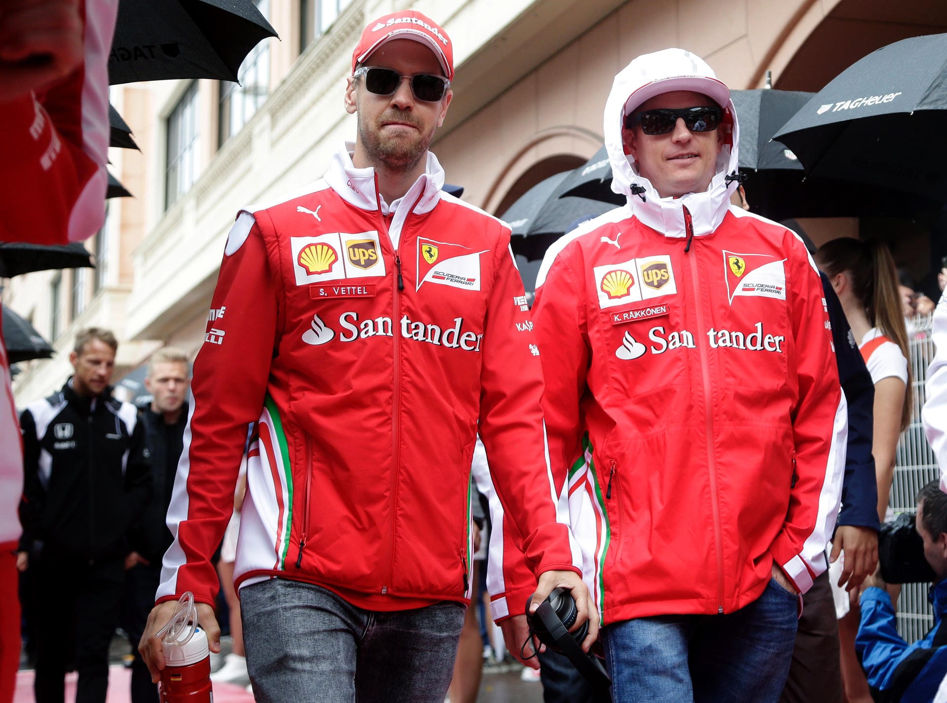 Die Ferrari-Piloten Sebastian Vettel (li.) und Kimi Räikkönen erscheinen im nassen Monaco zur Fahrerparade.