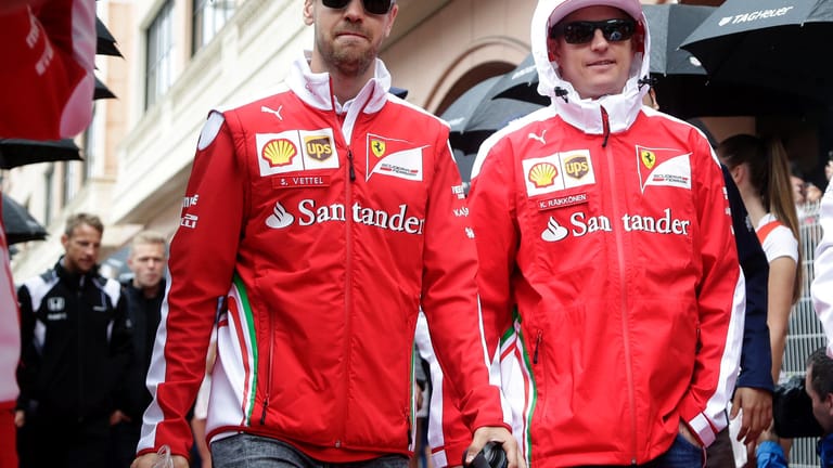 Die Ferrari-Piloten Sebastian Vettel (li.) und Kimi Räikkönen erscheinen im nassen Monaco zur Fahrerparade.