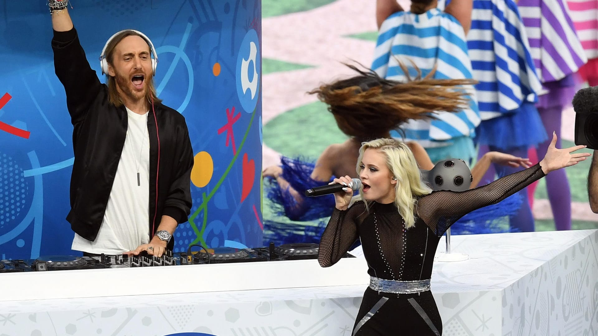 Dann taucht David Guetta (li.) aus einem riesigen Karussell im Mittelkreis auf und heizt dem Publikum ein. Zusammen mit der schwedischen Sängerin Zara Larsson gibt der französische Star-DJ den EM-Song "This One's For You" zum Besten.