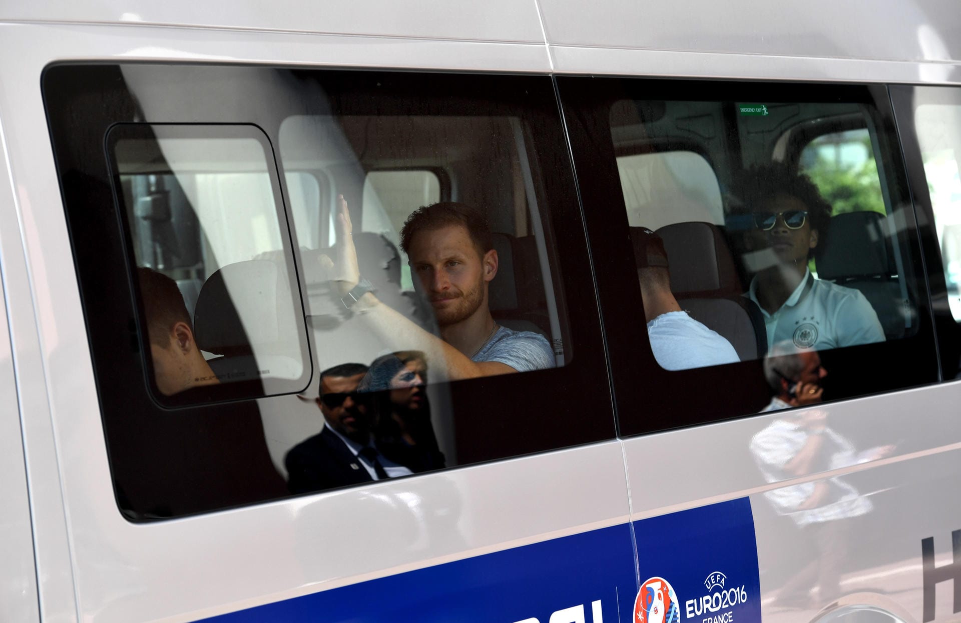 Benedikt Höwedes müht sich hinter der Scheibe des Vans zu lächeln und winkt zum letzten Mal aus der Hafenstadt.