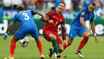 Die folgenschwere Szene: Bei der Aktion mit dem Franzosen Dimitri Payet (rechts, links Patrice Evra) wird Cristiano Ronaldo im EM-Finale verletzt.