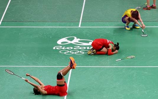 Auf den ersten Blick ist schwer zu sagen, wer hier enttäuschter ist. Alle drei Badmintonspielerinnen liegen am Boden. Bei den in rot gekleideten Indonesierinnen Nitya Krishinda Maheswari und Greysia Polii dürfte es vor allem die Anstrengung sein. Denn ihr knapper 2:0-Sieg (21:19, 21:19) gegen Kah Mun Vivian Hoo und Khe Wei Woon (MAS) aus Malaysia hat sichtbar viel Kraft gekostet.