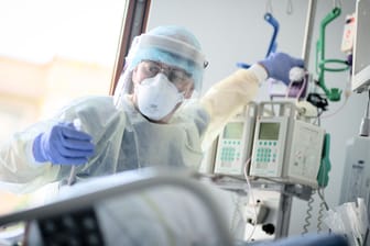Intensivpfleger am Bett einer Covid-Patientin (Archivbild): In den Berliner Krankenhäusern liegen wieder viele mit Corona infizierte Patienten.