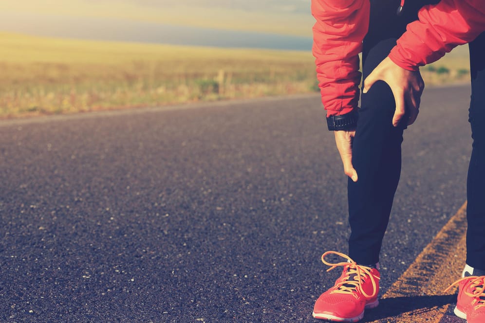 Ein Jogger greift sich ans Bein. Überanstrengungen beim Training können dazu führen, dass heftige Muskelschmerzen auftreten.