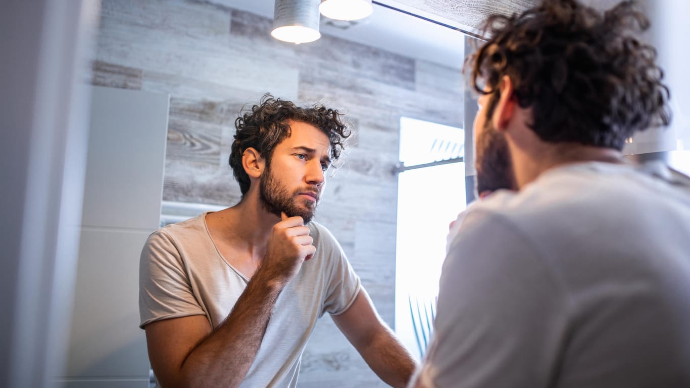 Man looks at himself in the mirror