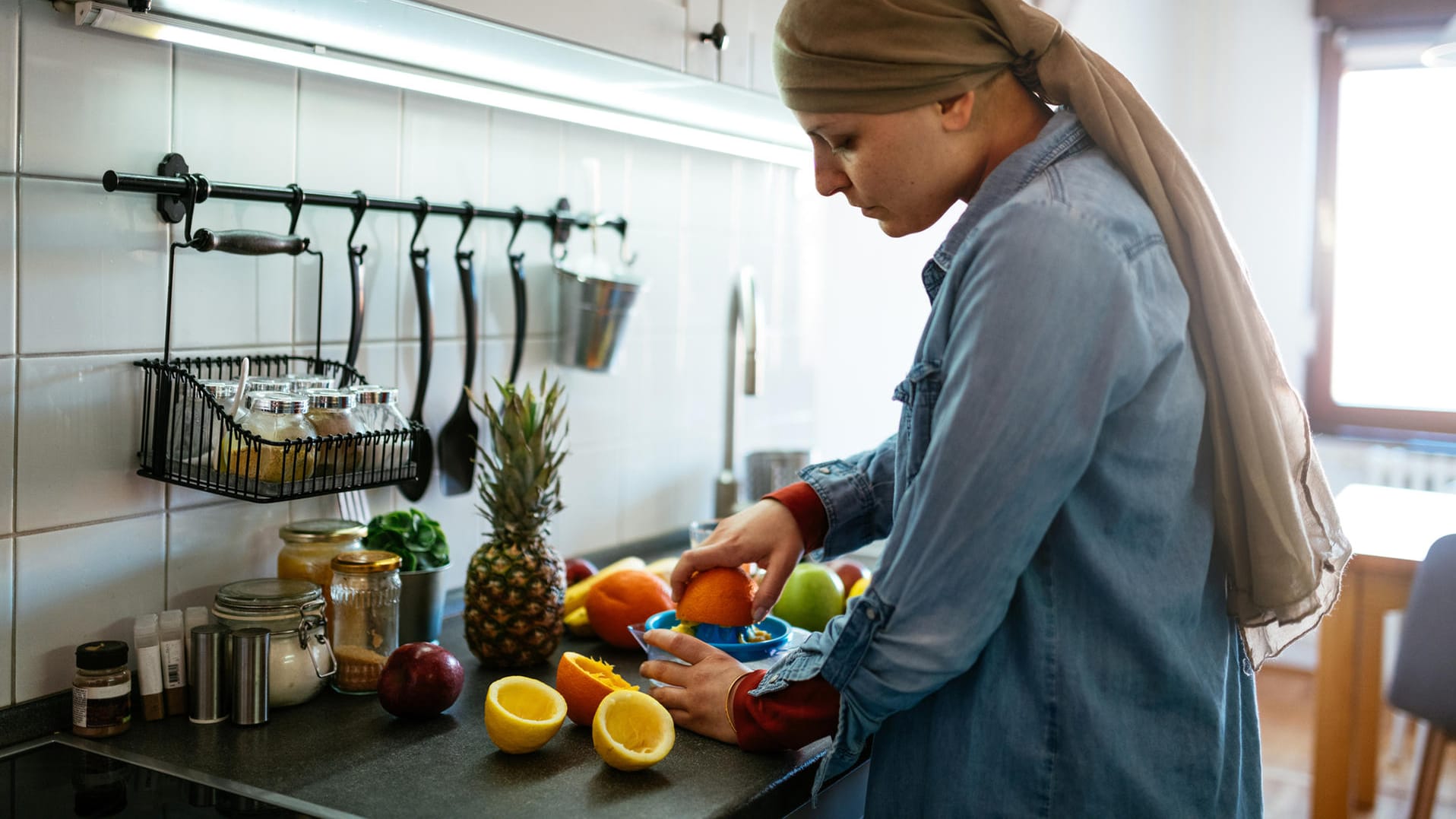 Eine junge Frau schneidet Obst: Eine vitaminreiche Ernährung unterstützt das Immunsystem.