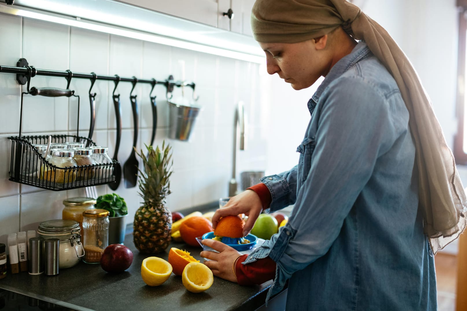 Eine junge Frau schneidet Obst: Eine vitaminreiche Ernährung unterstützt das Immunsystem.