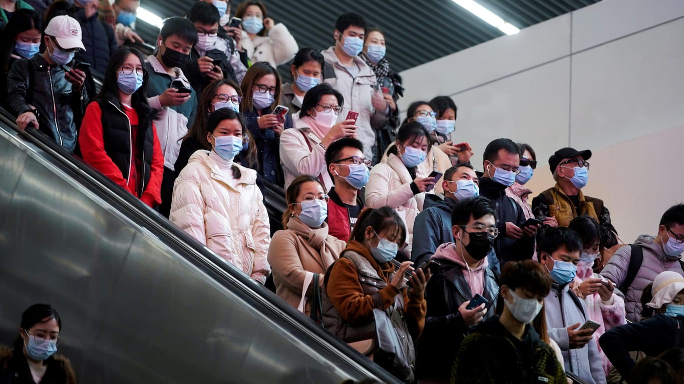 Menschen mit Maske in Shanghai: China sieht trotz Omikron die Olympischen Winterspiele nicht in Gefahr.