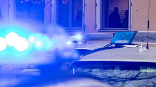 Polizeifahrzeuge stehen mit Blaulicht