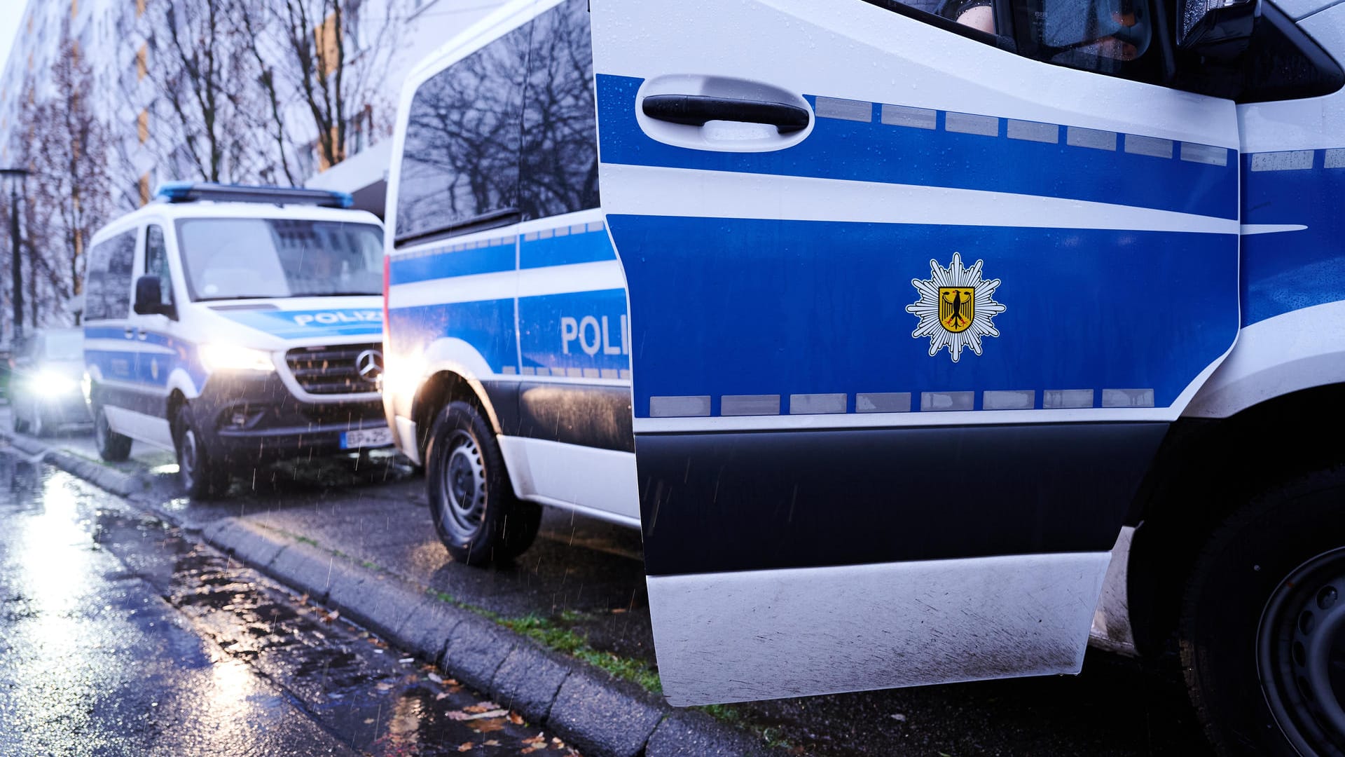 Fahrzeuge der Bundespolizei stehen vor einem Wohnhaus in der Landsberger Allee. Die Bundespolizei durchsucht seit dem frühen Mittwochmorgen 41 Objekte in drei Bundesländern im Zusammenhang mit dem Verdacht auf Schleuserkriminalität und der Vermittlung von Scheinvaterschaften. Schwerpunkt der Razzien ist mit 38 Objekten Berlin, wie ein Polizeisprecher am Morgen sagte.