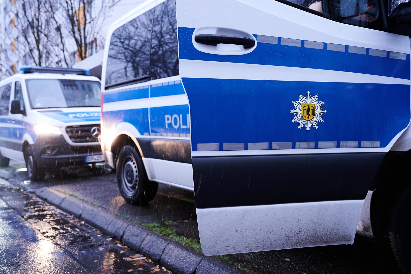 Fahrzeuge der Bundespolizei stehen vor einem Wohnhaus in der Landsberger Allee. Die Bundespolizei durchsucht seit dem frühen Mittwochmorgen 41 Objekte in drei Bundesländern im Zusammenhang mit dem Verdacht auf Schleuserkriminalität und der Vermittlung von Scheinvaterschaften. Schwerpunkt der Razzien ist mit 38 Objekten Berlin, wie ein Polizeisprecher am Morgen sagte.