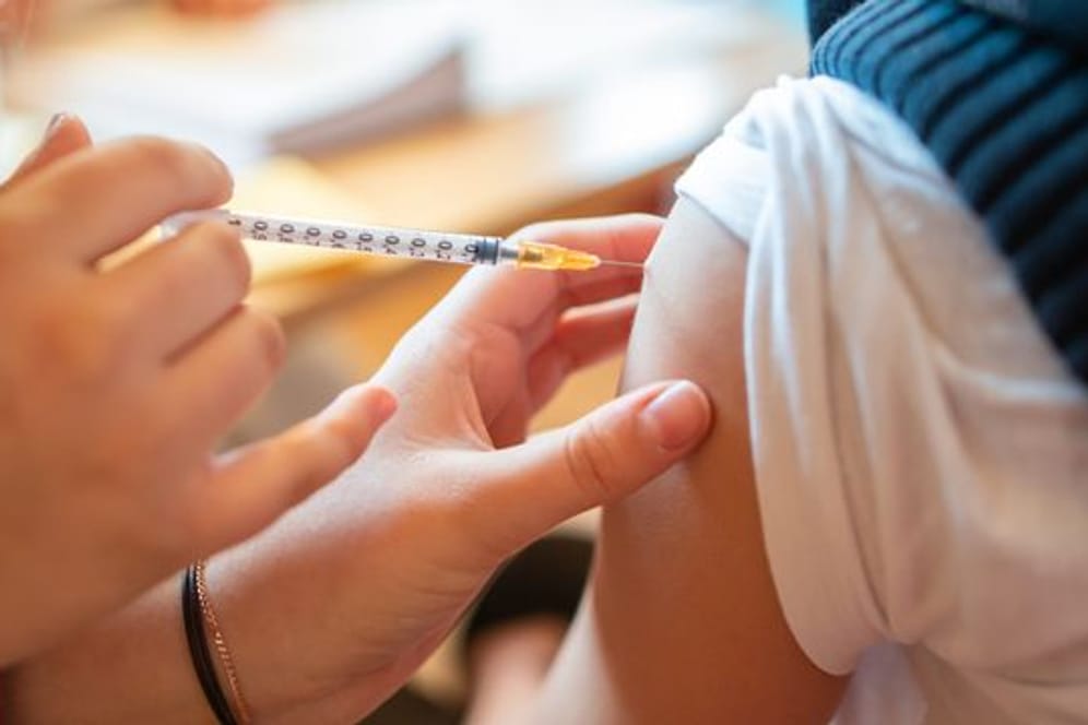 Ein Schüler bekommt eine Impfspritze in den Arm.