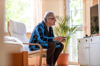 Ältere Mann vor dem Fernseher (Symbolbild): In bestimmten Fällen können sich auch Senioren vom Rundfunkbeitrag befreien lassen.