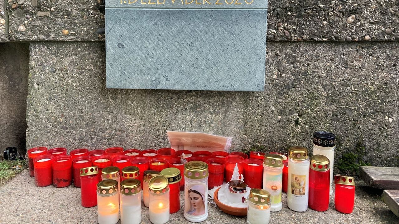 Vor einer Gedenktafel zur Amokfahrt in Trier haben Bürger Kerzen aufgestellt.