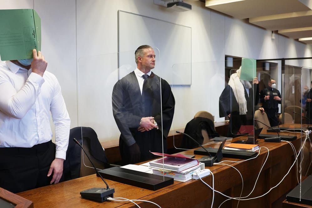 Zwei Angeklagte halten sich beim Prozessauftakt Anfang Dezember eine Mappe vor das Gesicht: Ihnen wird die Vergewaltigung einer jungen Frau vorgeworfen.