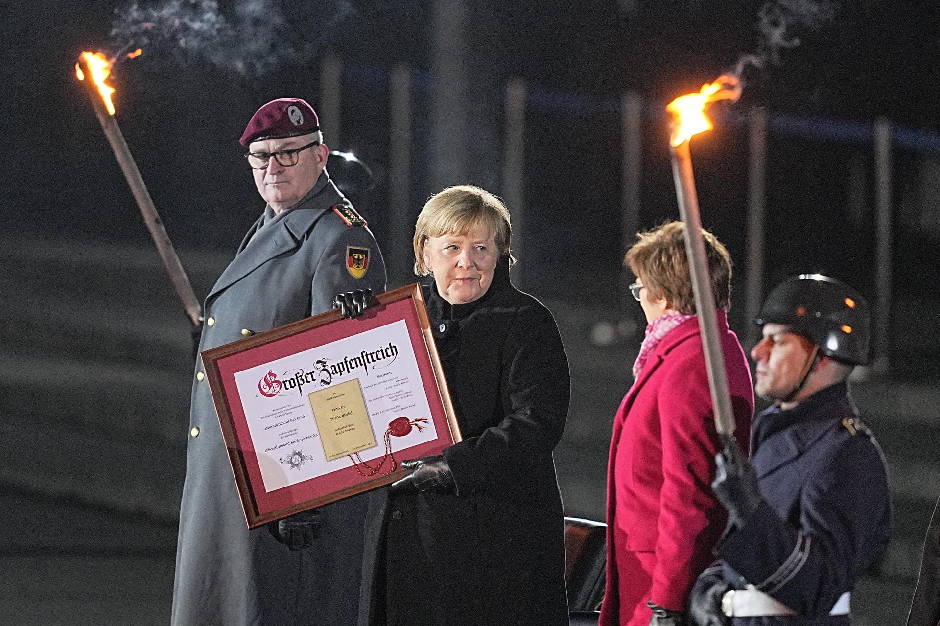 Verabschiedung durch die Bundeswehr: Der Kanzlerin wird eine Urkunde des Wachbataillons des Bundesministeriums für Verteidigung überreicht.
