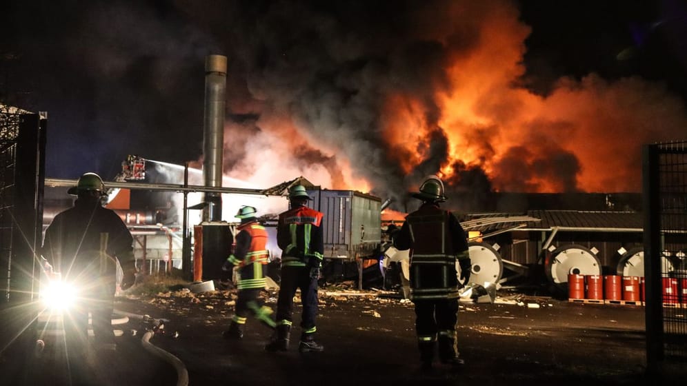 Feuerwehrleute löschen den Brand in einer Tapetenfabrik.