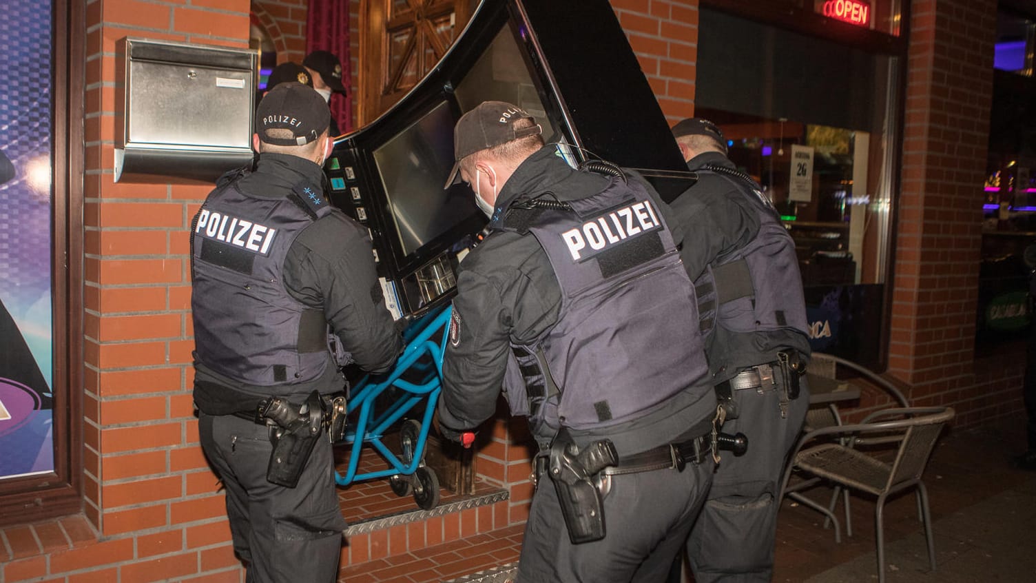 Polizeikräfte schaffen einen Spielautomaten aus einem durchsuchten Lokal: Das eigentliche Ziel der Razzia war illegales Glücksspiel. Polizeikräfte schaffen einen Spielautomaten aus einem durchsuchten Lokal: Das eigentliche Ziel der Razzia war illegales Glücksspiel.