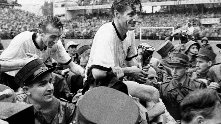 Mit dem sensationellen WM-Erfolg 1954 in der Schweiz machte sich Eckel unsterblich. Nach dem Finalsieg gegen die favorisierten Ungarn trug ihn das Berner Publikum, gemeinsam mit Kapitän Fritz Walter (re.) auf Schultern.
