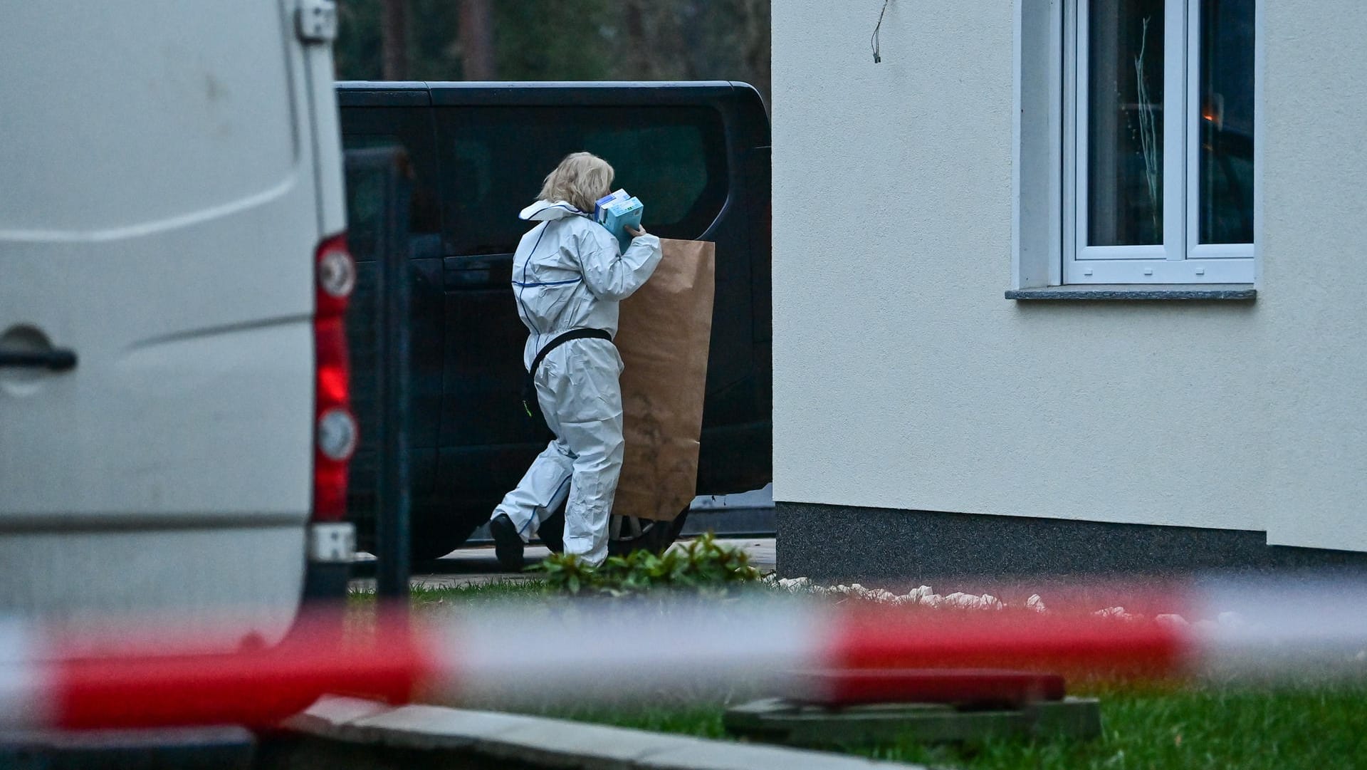 Eine Kriminaltechnikerin an einem Einfamilienhaus in Senzig: Die Ermittler untersuchen derzeit den Tatort.