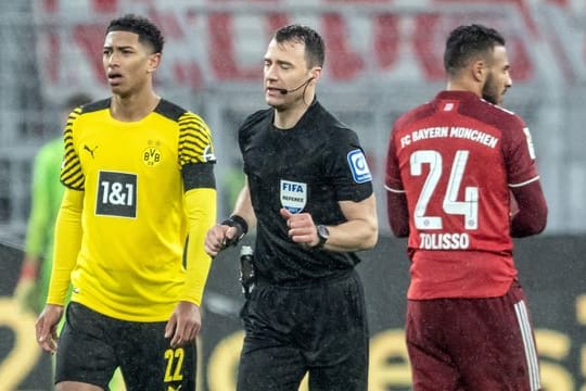 Schiedsrichter Felix Zwayer (M) läuft an Dortmunds Jude Bellingham vorbei, um sich den Videobeweis anzuschauen.