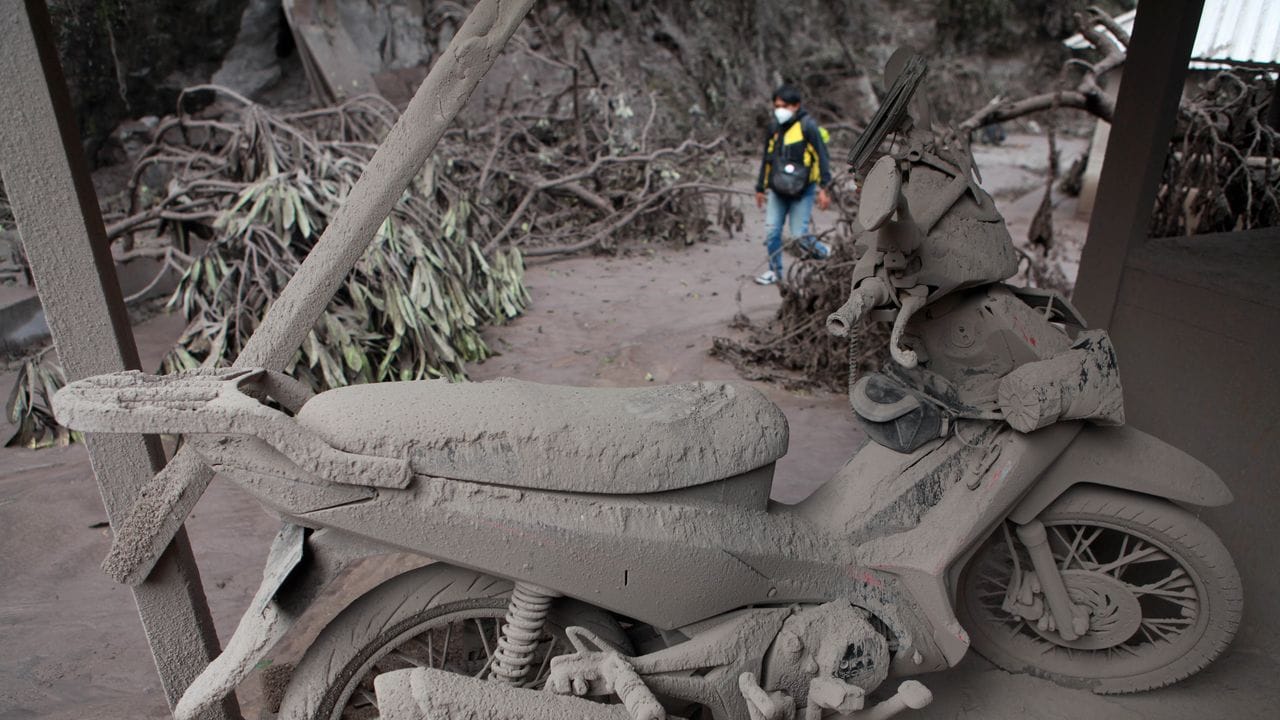 Von Vulkanasche gedecktes Motorrad nach dem Ausbruch des Vulkans Semeru im Dorf Sumberwuluh auf Java.
