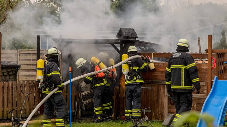 Feuerwehrmänner löschen einen Brand in einer Gartenhütte (Symbolbild): Der mutmaßliche Täter soll unter anderem in einer Gartenlaube Feuer gelegt haben.