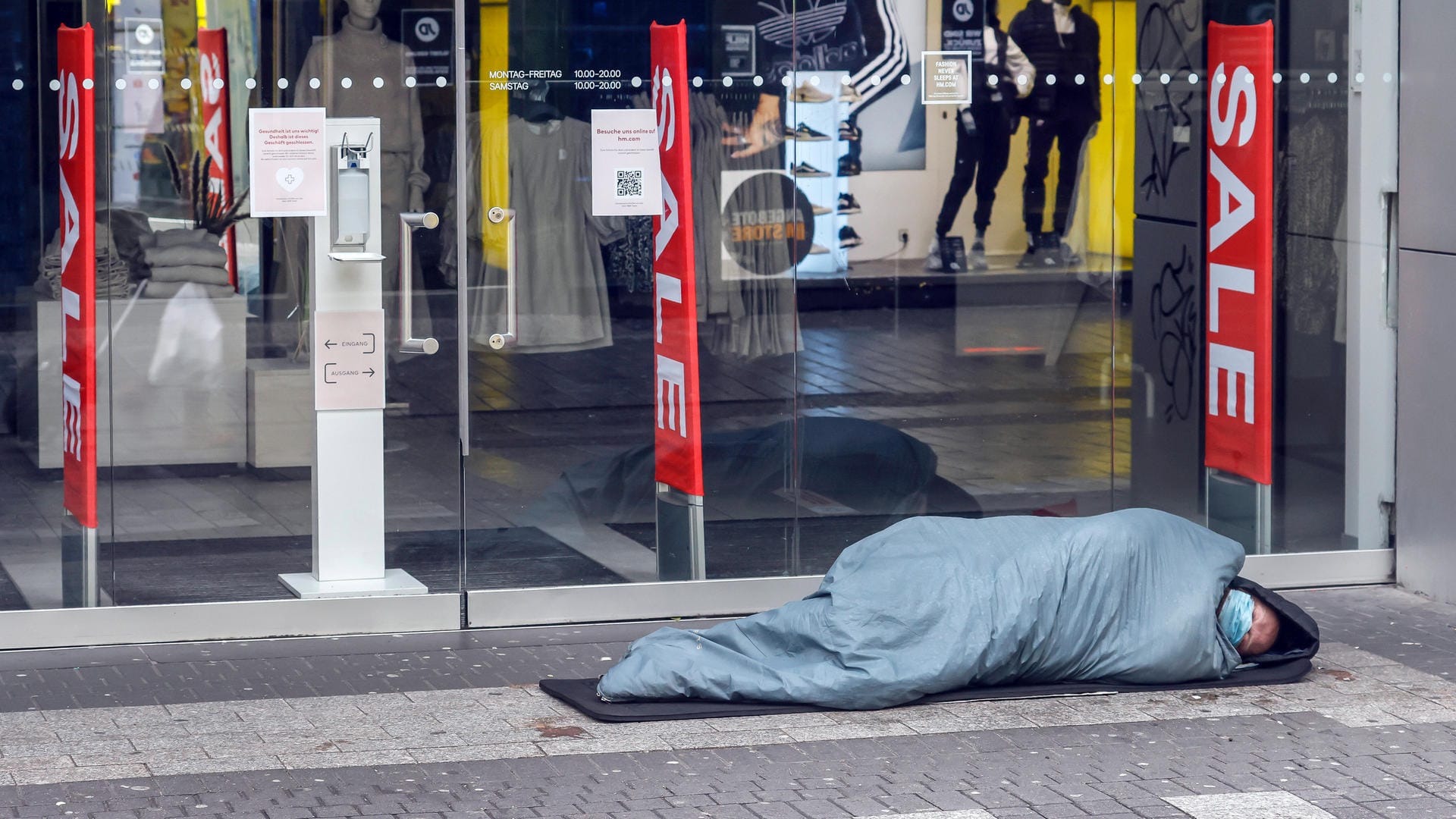 Ein Obdachloser schläft vor einem geschlossenen Modegeschäft in Köln (Symbolbild): Eisige Temperaturen wie in diesem Winter sind für obdachlose Menschen lebensbedrohlich.