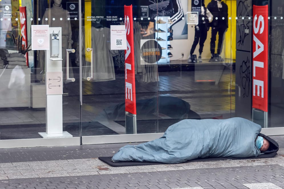 Ein Obdachloser schläft vor einem geschlossenen Modegeschäft in Köln (Symbolbild): Eisige Temperaturen wie in diesem Winter sind für obdachlose Menschen lebensbedrohlich.