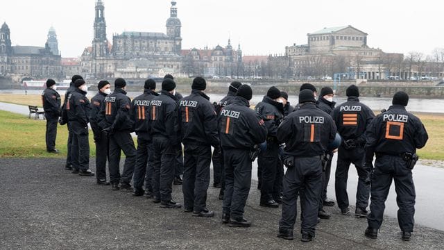 Polizisten stehen am Ufer der Elbe