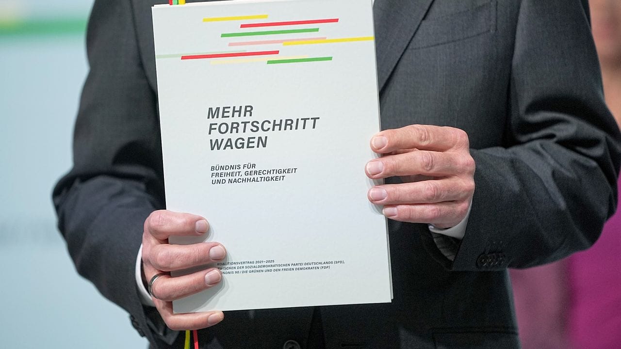 Der designierte Bundeskanzler Olaf Scholz mit dem Vertrag seiner Regierungskoalition.
