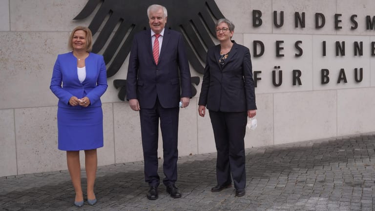 Nancy Faeser (l-r, SPD), Bundesinnenministerin, Horst Seehofer (CSU), ehemaliger Bundesinnenminister, und Klara Geywitz (SPD), Bundesbauministerin, stehen am Eingang des Bundesinnenministeriums.