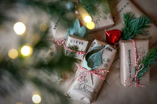 Nicht nur nachhaltiger, sondern auch etwas Besonderes: Selbst bedrucktes Geschenkpapier, dekoriert mit Zweigen.