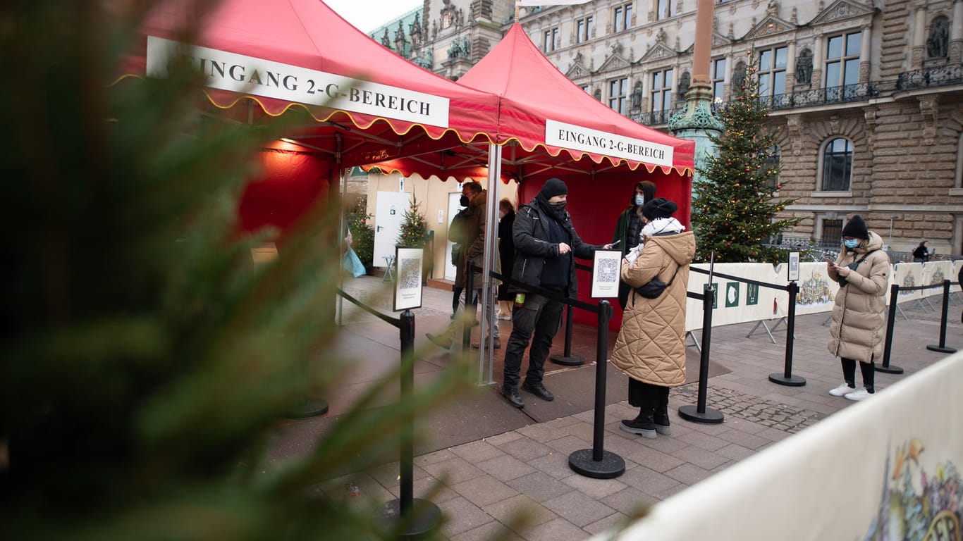 An einem Eingang zum Weihnachtsmarkt auf dem Rathausmarkt wird die Einhaltung der 2G-Regel kontrolliert. Zugang zu dem Bereich des Marktes haben nur geimpfte oder genesene Personen.