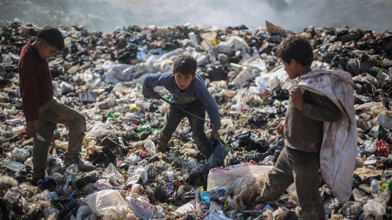 Syrische Kinder suchen auf einer Mülldeponie in der Nähe des Grenzübergangs Bab al-Hawa nach wiederverwertbaren Abfällen wie Plastik und Altmetall.