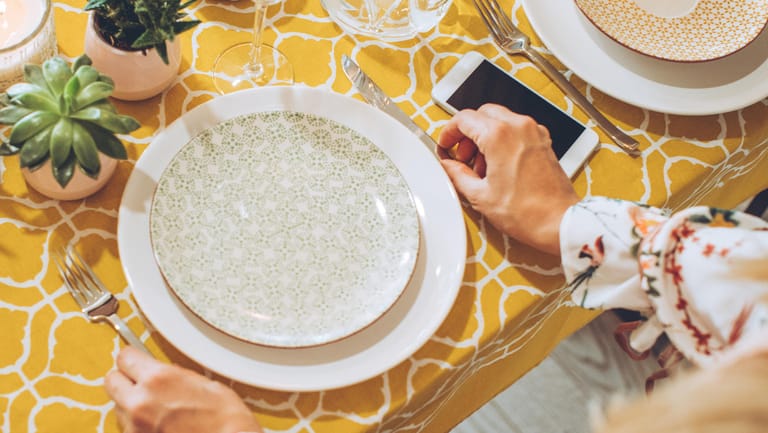 Anstand am Tisch: Das Handy sollte nicht auf dem Tisch liegen – auch nicht, um einen Platz "zu reservieren".